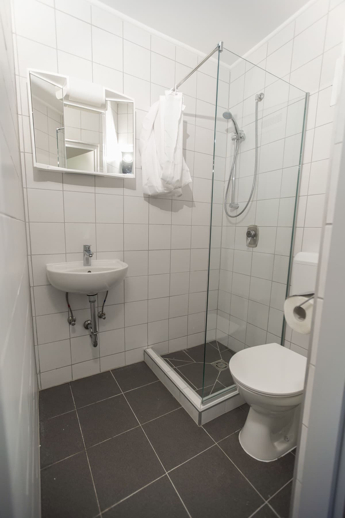 Bad mit Dusche, Waschbecken und Spiegel